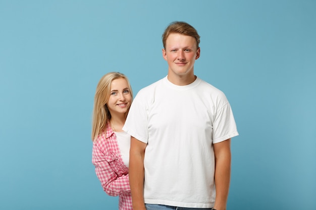 Jonge lachende mooie paar twee vrienden man en vrouw in wit roze lege lege t-shirts poseren