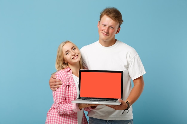 Jonge lachende paar twee vrienden man en vrouw in wit roze t-shirts poseren