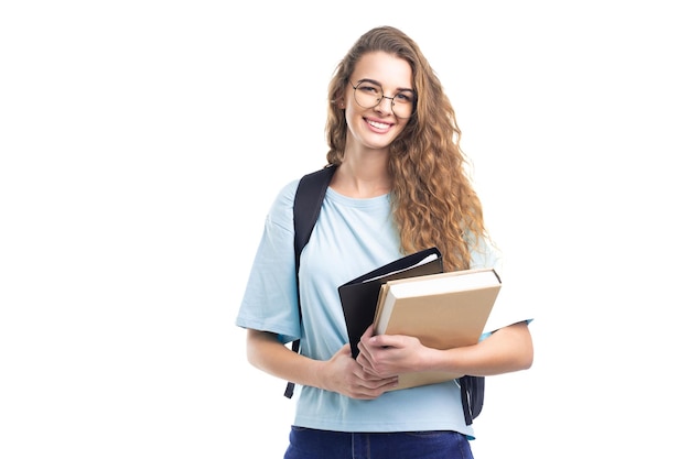 Jonge lachende student meisje houdt boeken vast terwijl ze naar de camera kijkt over witte achtergrond onderwijs