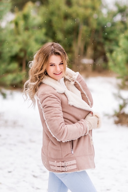 Jonge lachende vrouw in roze kleren in een winter forest