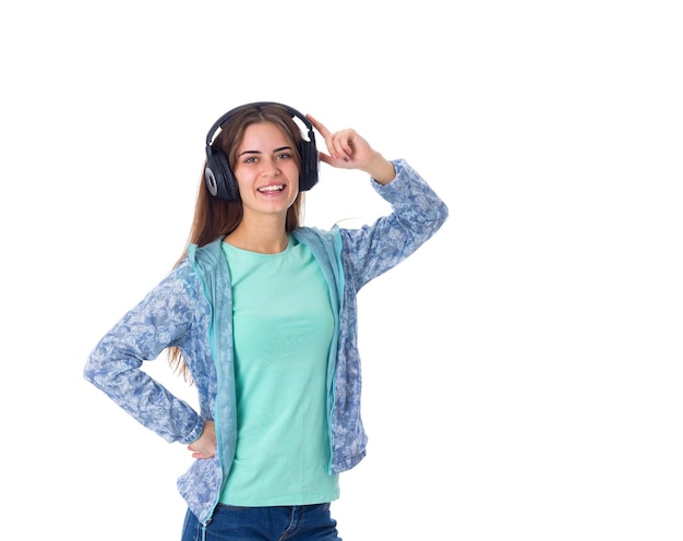 Jonge lachende vrouw met bruin haar in blauw shirt in zwarte koptelefoon op witte achtergrond in studio