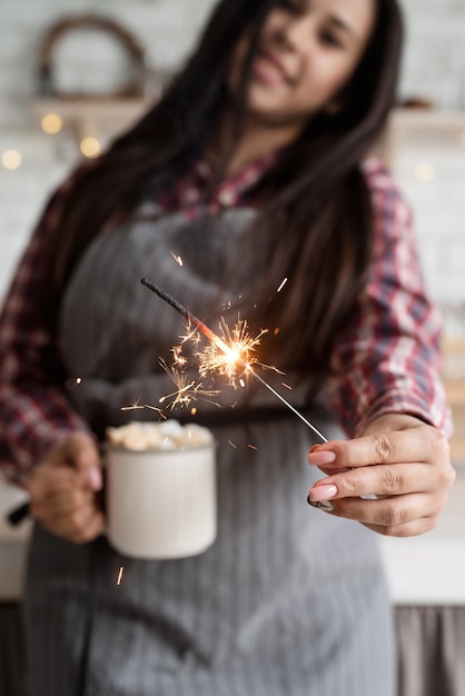 Jonge lachende vrouw met een kopje heemst cacao en een sterretje vieren Kerstmis