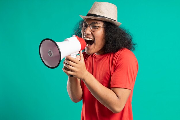 Jonge lange haren man poseren met een megafoon. aankondiging concept