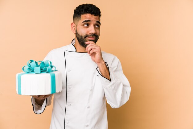 Jonge Latijns-bakkersmens die een cake houdt