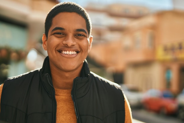 Jonge Latijns-man glimlachend gelukkig staande in de stad