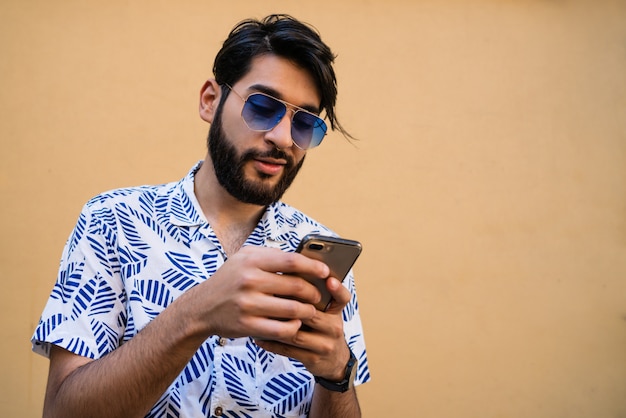 Jonge Latijns-man met zijn mobiele telefoon.