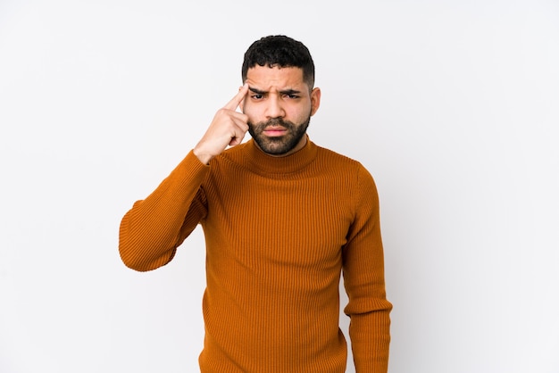 Jonge Latijns-man tegen een witte muur geïsoleerd met een teleurstelling gebaar met wijsvinger.