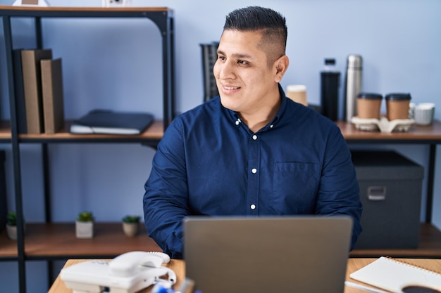 Jonge Latijns-man zakelijke werknemer met behulp van laptop werken op kantoor