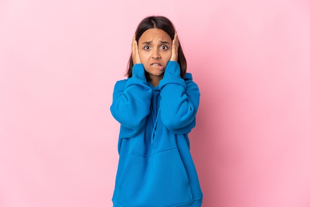 Jonge Latijns-vrouw die op roze muur wordt geïsoleerd die zenuwachtig gebaar doet