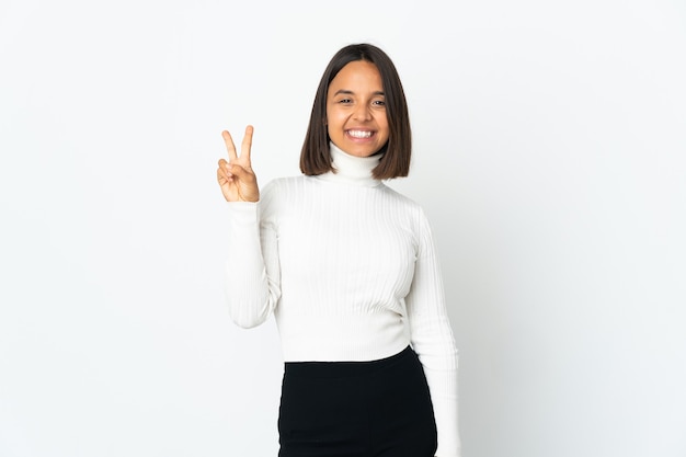 Jonge Latijns-vrouw geïsoleerd glimlachend en overwinningsteken tonen