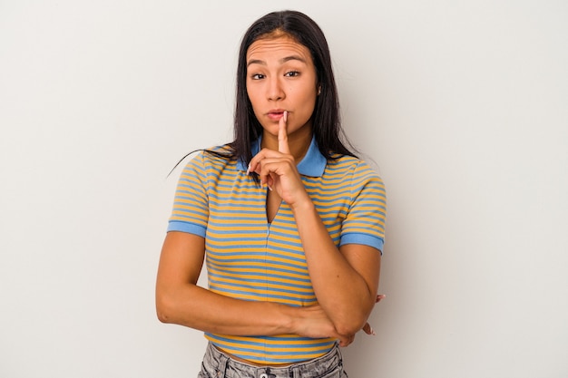 Jonge Latijns-vrouw geïsoleerd op een witte achtergrond op zoek zijwaarts met twijfelachtige en sceptische uitdrukking.