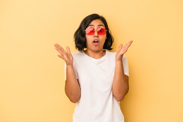 Jonge Latijns-vrouw geïsoleerd op gele achtergrond met een idee, inspiratie concept.