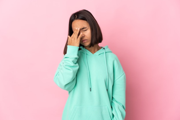 Jonge Latijns-vrouw geïsoleerd op roze achtergrond met hoofdpijn