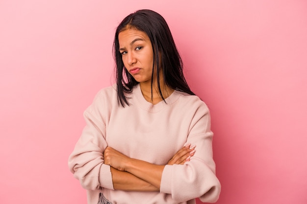 Jonge Latijns-vrouw geïsoleerd op roze achtergrond ongelukkig in de camera kijken met sarcastische uitdrukking.