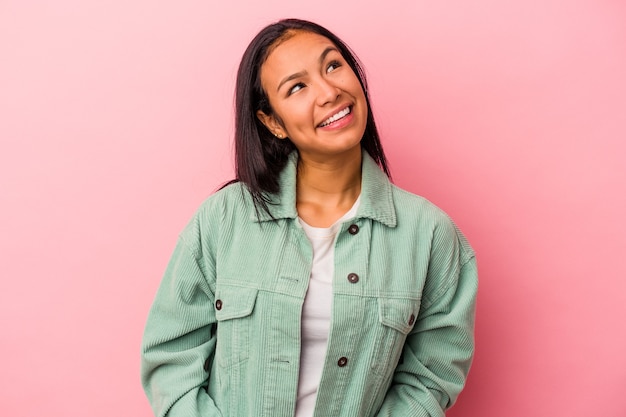 Jonge Latijns-vrouw geïsoleerd op roze achtergrond ontspannen en gelukkig lachen, nek uitgerekt met tanden.