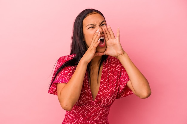 Jonge Latijns-vrouw geïsoleerd op roze achtergrond opgewonden schreeuwen naar voren.