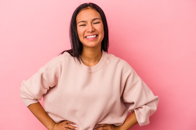 Jonge Latijns-vrouw geïsoleerd op roze achtergrond vertrouwen houden handen op de heupen.