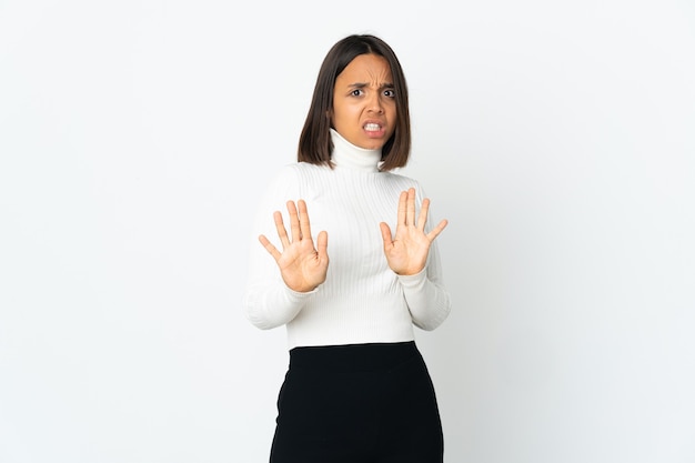 Jonge Latijns-vrouw geïsoleerd op witte achtergrond nerveus handen naar voren strekken