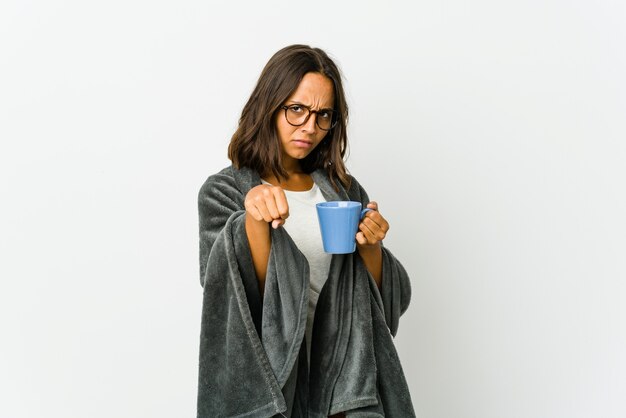 Jonge Latijns-vrouw met deken geïsoleerd op een witte muur een klap, woede gooien, vechten als gevolg van een argument.