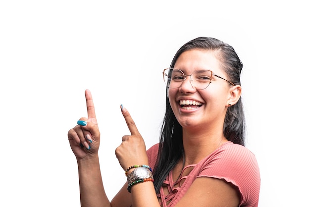 Jonge Latijns-vrouw met lachende bril wijzend op witte achtergrond