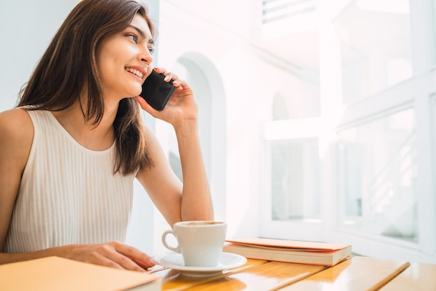 Jonge latijns-vrouw praten over de telefoon.