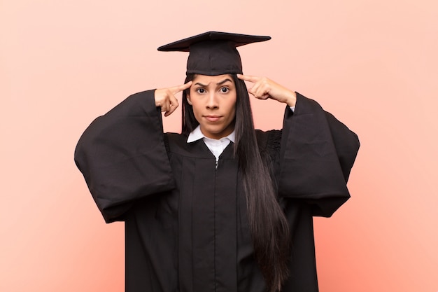 Jonge Latijnse studente met een serieuze en geconcentreerde blik, brainstormend en nadenkend over een uitdagend probleem