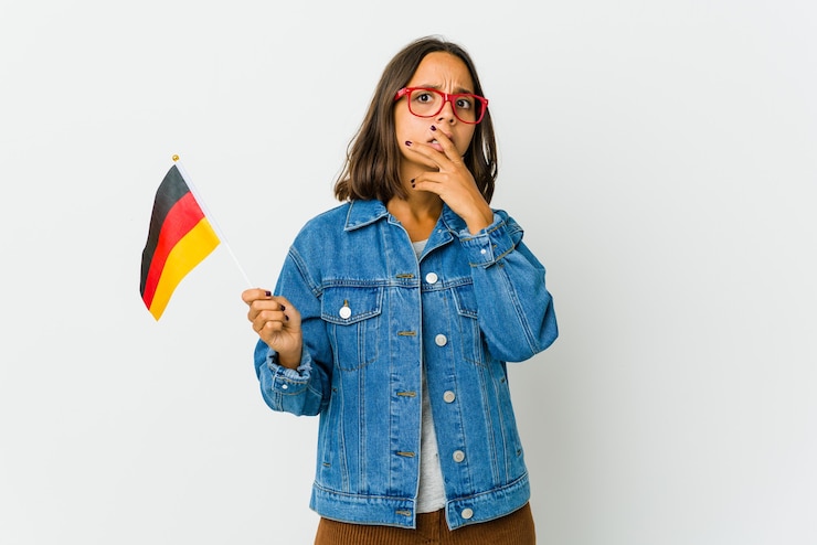 Foto jonge latijnse vrouw die een duitse vlag houdt die op witte muur wordt geïsoleerd bang en bang.