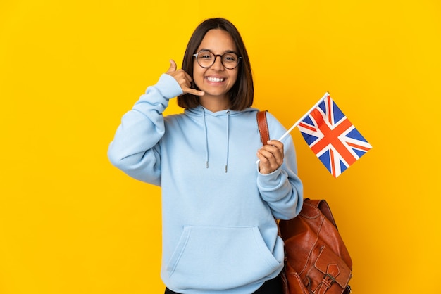 Jonge Latijnse vrouw die een geïsoleerde vlag van het Verenigd Koninkrijk houdt