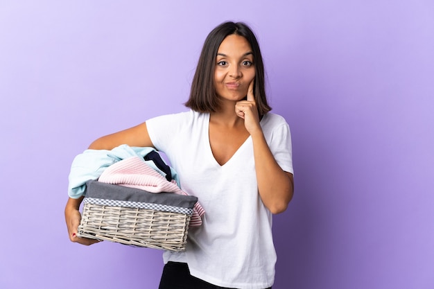 Jonge Latijnse vrouw die een wasmand houdt