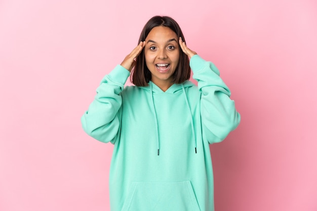 Jonge Latijnse vrouw die op roze muur met verrassingsuitdrukking wordt geïsoleerd