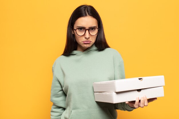 Jonge Latijnse vrouw die verdrietig en zeurderig is met een ongelukkige blik, huilend met een negatieve en gefrustreerde houding