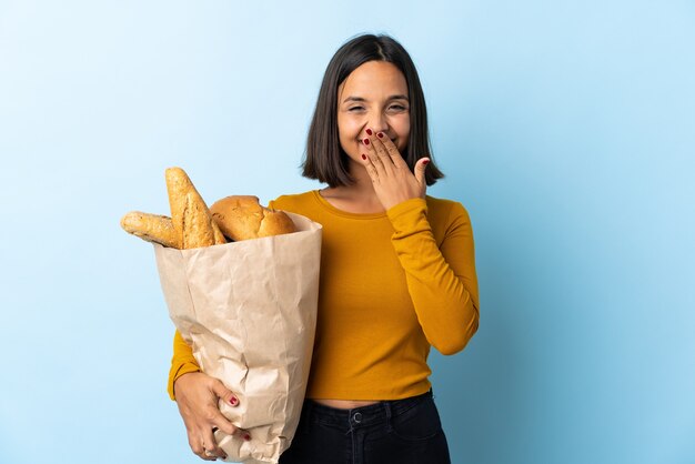 Jonge Latijnse vrouw die wat brood koopt