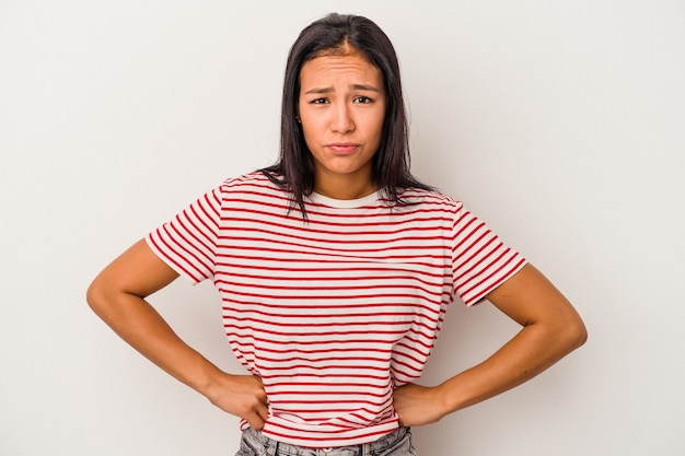 Jonge latijnse vrouw geïsoleerd op een witte achtergrond verward, voelt zich twijfelachtig en onzeker.