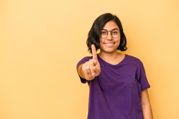 Jonge latijnse vrouw geïsoleerd op gele achtergrond die zich verdrietig en peinzend voelt, kijkend naar kopieerruimte.