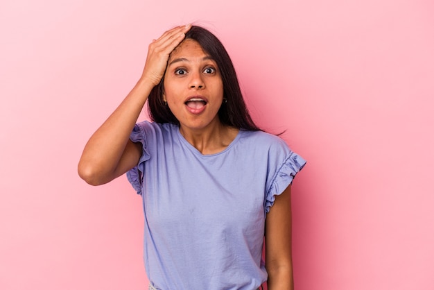 Jonge latijnse vrouw geïsoleerd op roze achtergrond geschokt, ze heeft belangrijke ontmoeting onthouden.