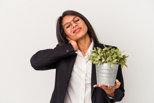 Jonge latijnse zakenvrouw met planten geïsoleerd op een witte achtergrond die de achterkant van het hoofd aanraakt, denkt en een keuze maakt.