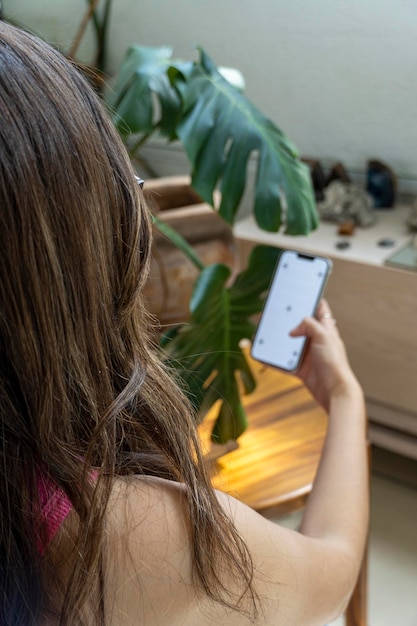 Jonge latina vrouw op haar mobiele telefoon verschillende activiteiten wit scherm mockup of groen scherm