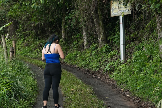 Jonge latina-vrouw verdwaald op een pad op zoek naar aanwijzingen om eruit te komen meisje dat op een pad staat