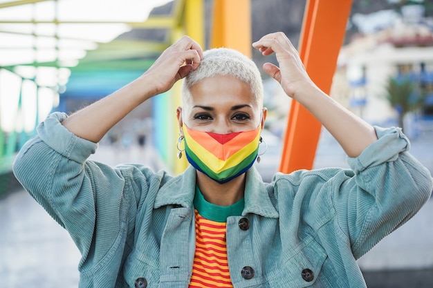 Jonge lesbienne die LGBT-regenboogvlag-trotsmasker draagt - Focus on face