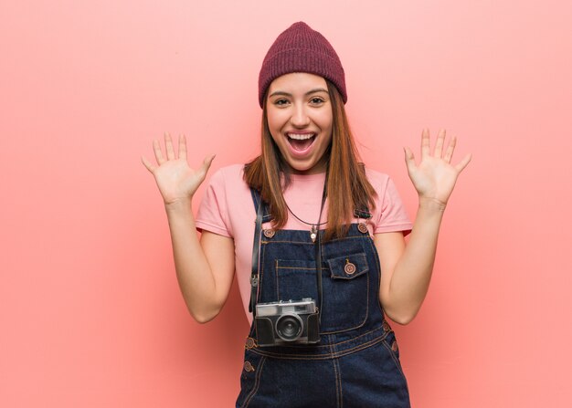 Jonge leuke fotograafvrouw die een overwinning of een succes viert