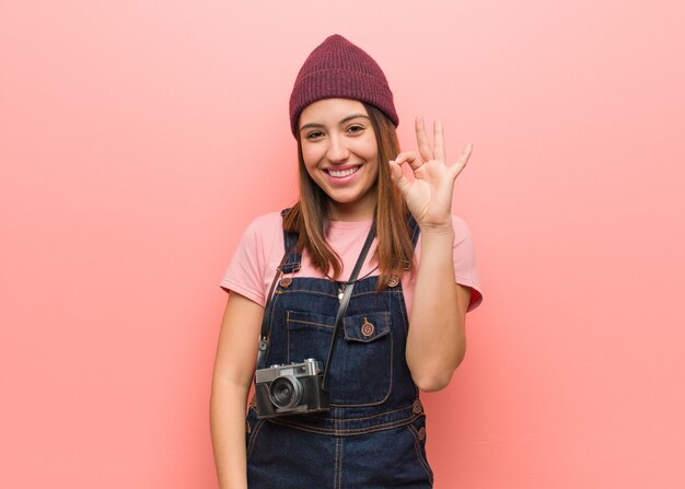 Jonge leuke fotograafvrouw vrolijk en zeker die ok gebaar doen