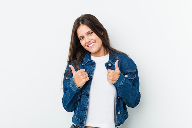 Jonge leuke vrouw beide duimen omhoog, glimlachen en zelfverzekerd.