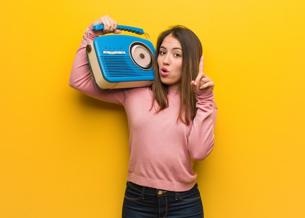 Jonge leuke vrouw die een uitstekende radio houdt die een groot idee, concept creativiteit heeft