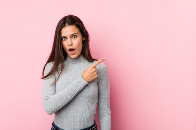 Jonge leuke vrouw die naar de kant wijst