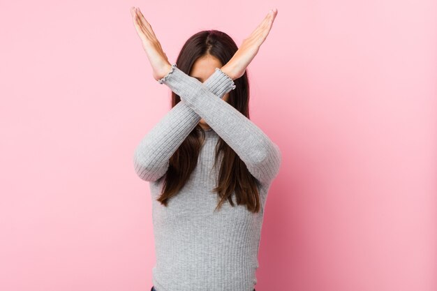 Jonge leuke vrouw die twee gekruiste wapens, dinial concept houdt.