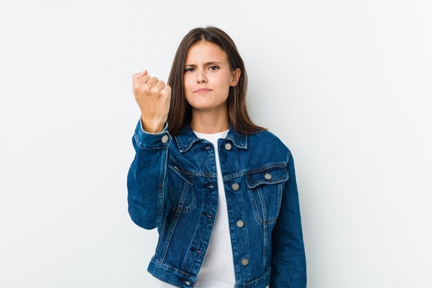 Jonge leuke vrouw die vuist met agressieve gelaatsuitdrukking toont.