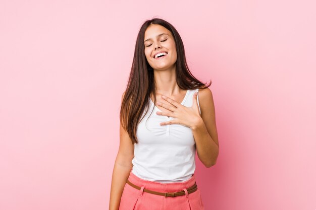 Jonge leuke vrouw lacht hardop hand op de borst te houden.