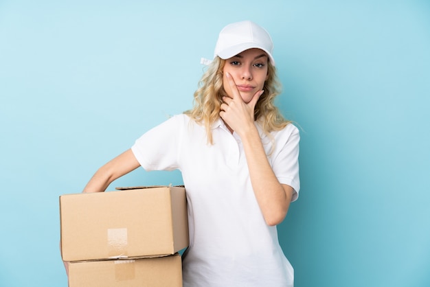 Jonge leveringsvrouw die op blauw een idee denken