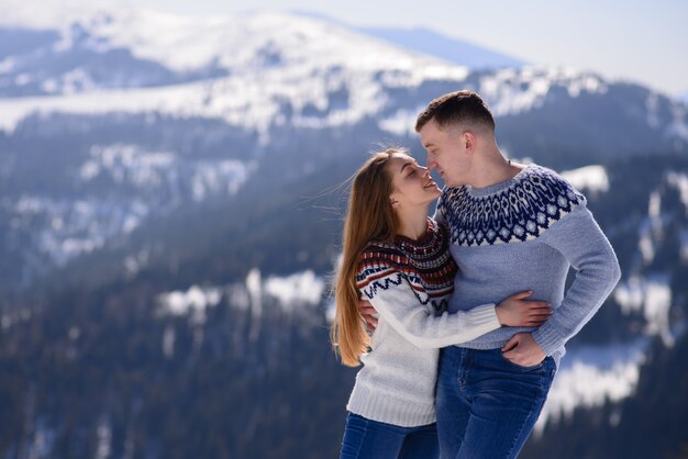 Jonge liefdevolle paar op een datum op de top van een besneeuwde berg