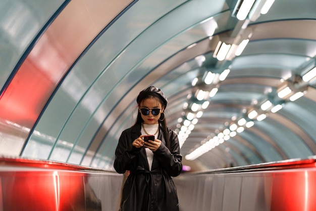 Foto jonge lifestyle blogger koreaans meisje post op sociale media rit roltrap vanaf metrostation